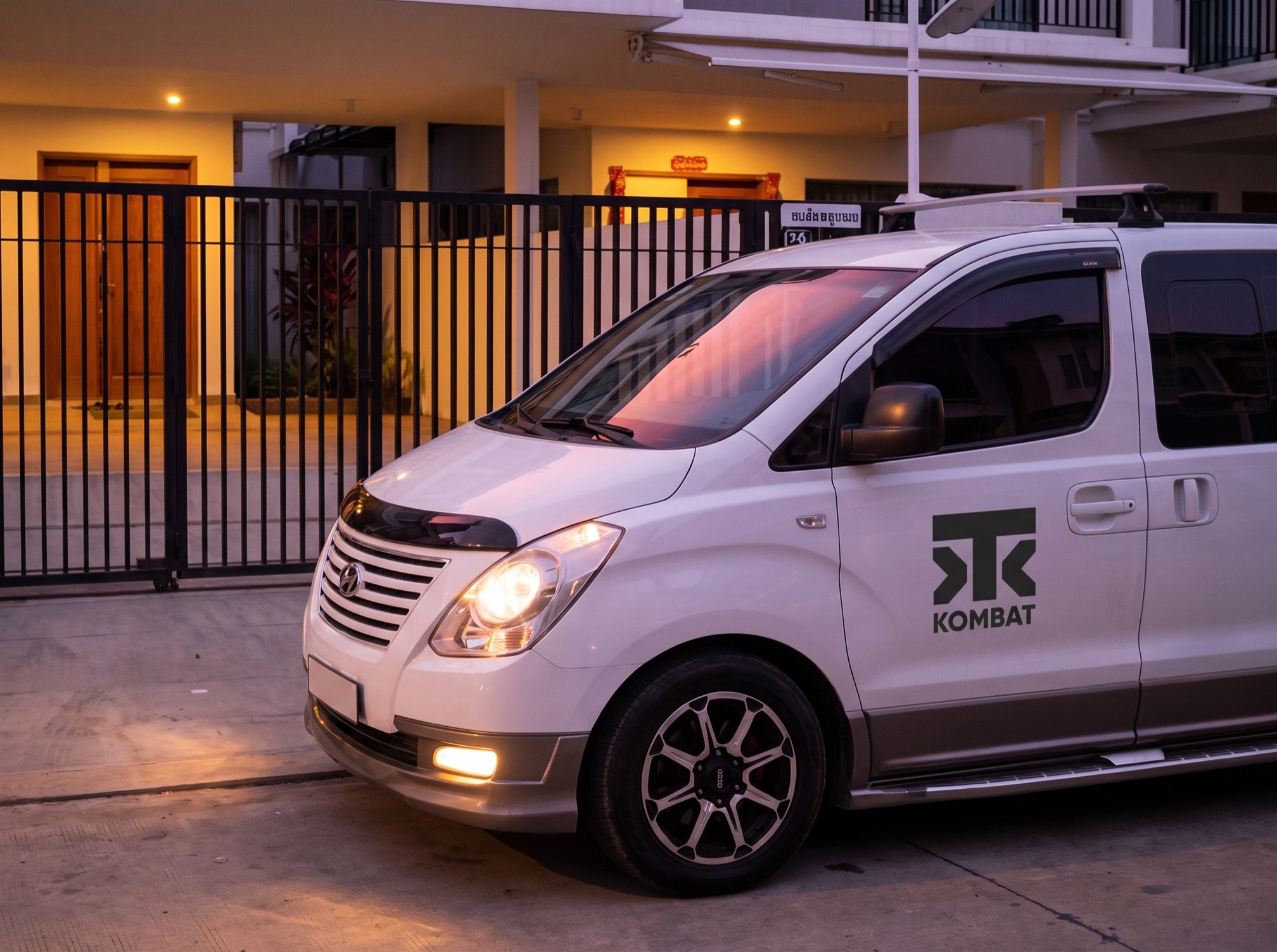 The house van waiting at dusk, headlights on